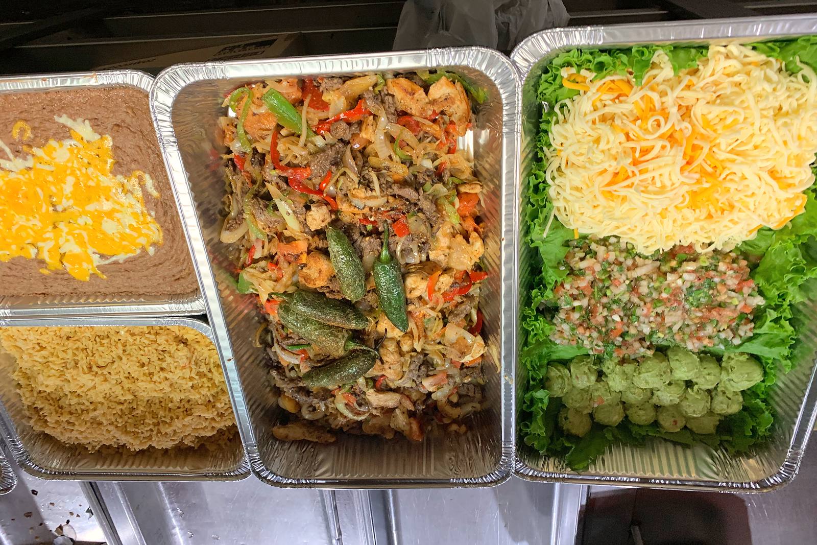 Catering trays of fajitas, rice, beans and fixings