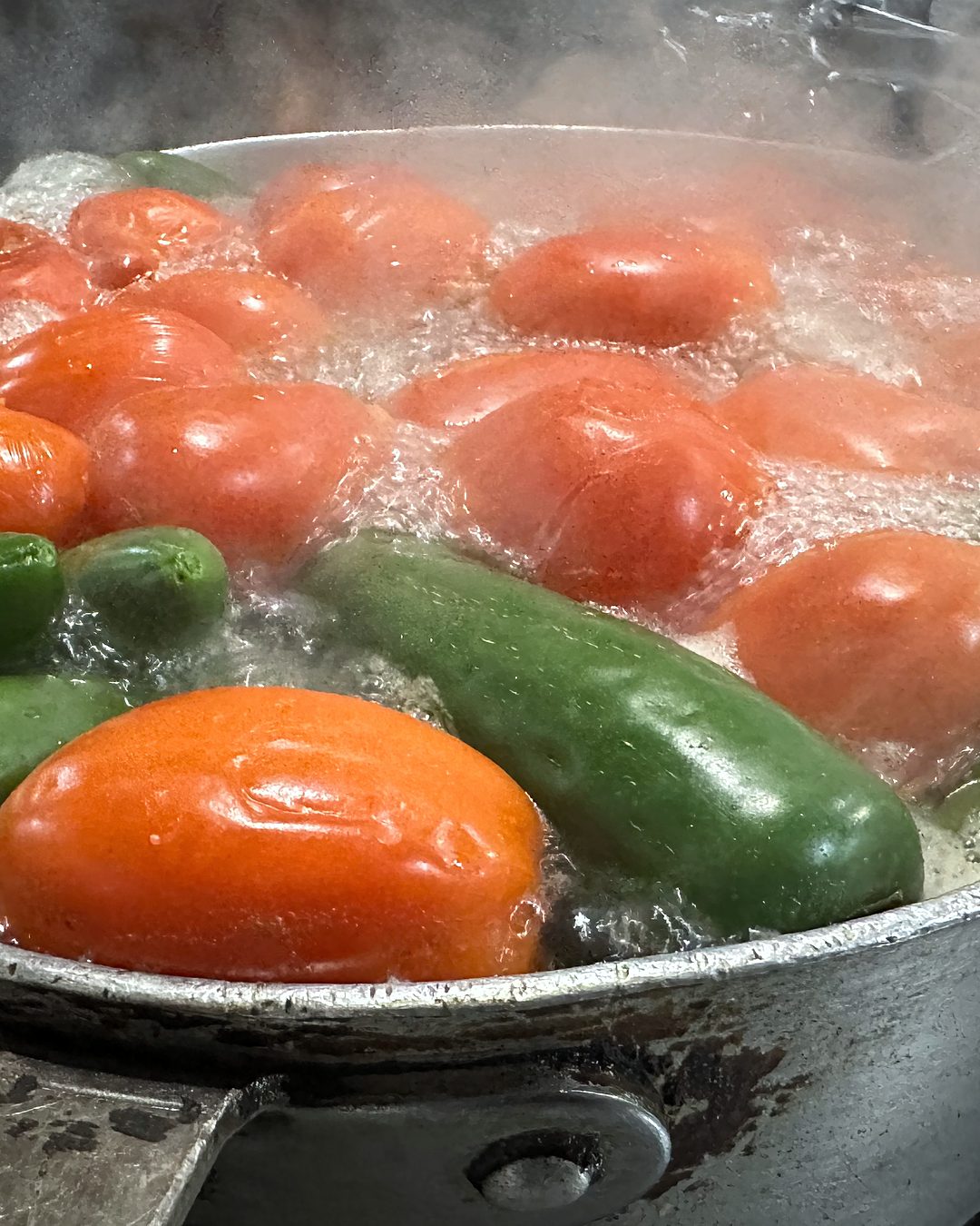 Tomatoes and jalapeños simmering on the stove